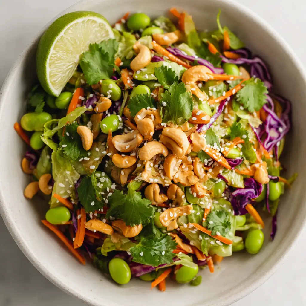 Edamame Crunch Salad with Sesame Ginger Vinaigrette 2 A close-up macro shot of the healthy edamame salad, showing the detailed textures of the shredded cabbage, carrots, quinoa, and fresh cilantro.