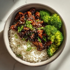 An overhead shot of a finished Teriyaki Chicken Bowl, showcasing the vibrant green broccoli and glistening chicken on a bed of fluffy rice.
