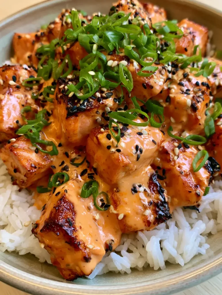 Top down view of Bang Bang Salmon Rice Bowls garnished with sesame seeds and scallions.