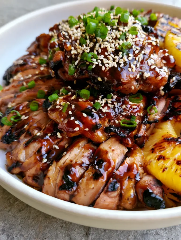Hawaiian Teriyaki Chicken: The Ultimate Sizzling Grilled Pineapple Recipe 2 Glistening sliced grilled chicken thighs coated in dark teriyaki sauce with green onion garnish. (Hawaiian Teriyaki Chicken)