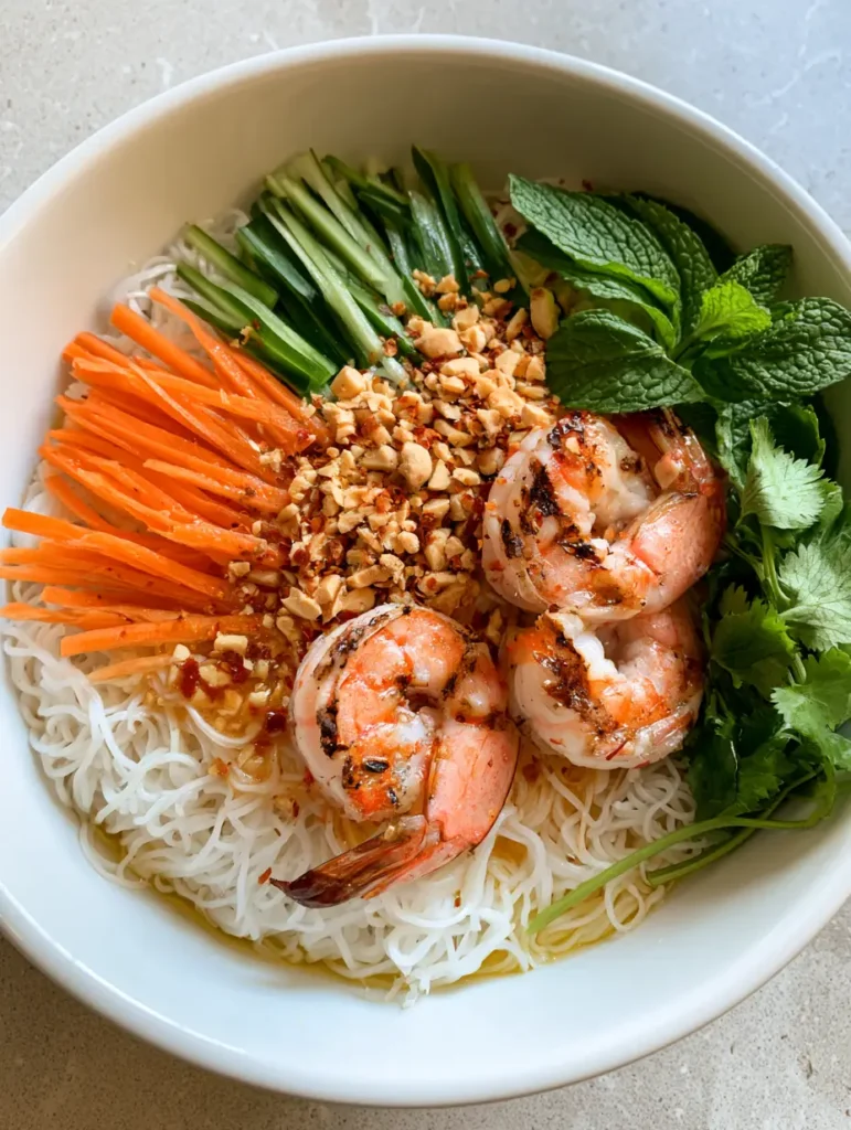 Close up of charred shrimp and crushed peanuts on top of a Vietnamese Noodle Salad.