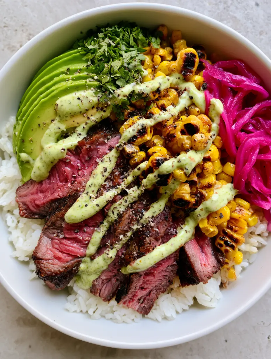 Close-up of a Steak and Avocado Bowl showing medium-rare sirloin steak with a pink center and browned crust on a bed of white rice.