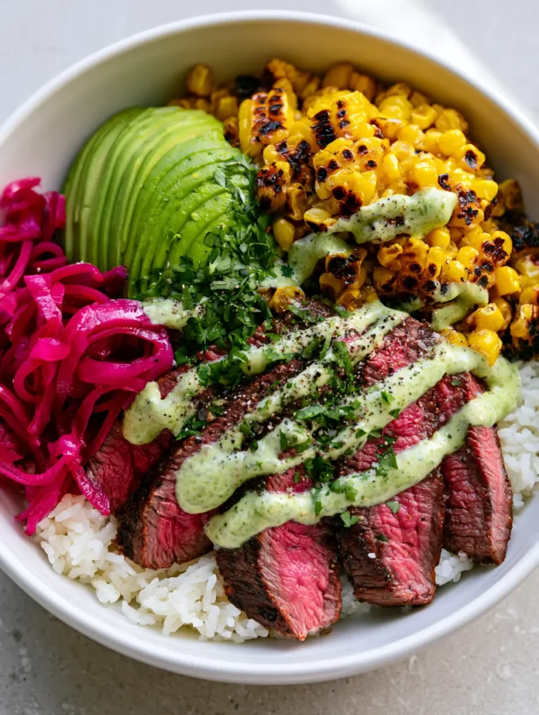 Overhead shot of the completed Steak and Avocado Bowl with vibrant magenta pickled onions and golden charred corn.